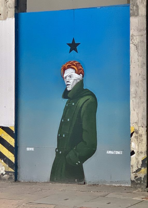 a mural of a man with a black star on a blue wall