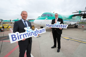 two men holding signs in front of an airplane