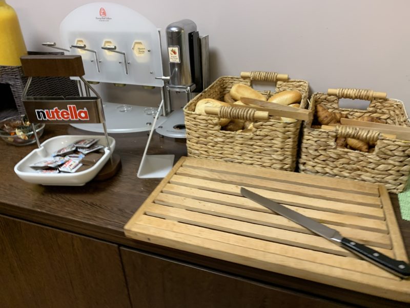 a knife on a cutting board next to baskets of bread