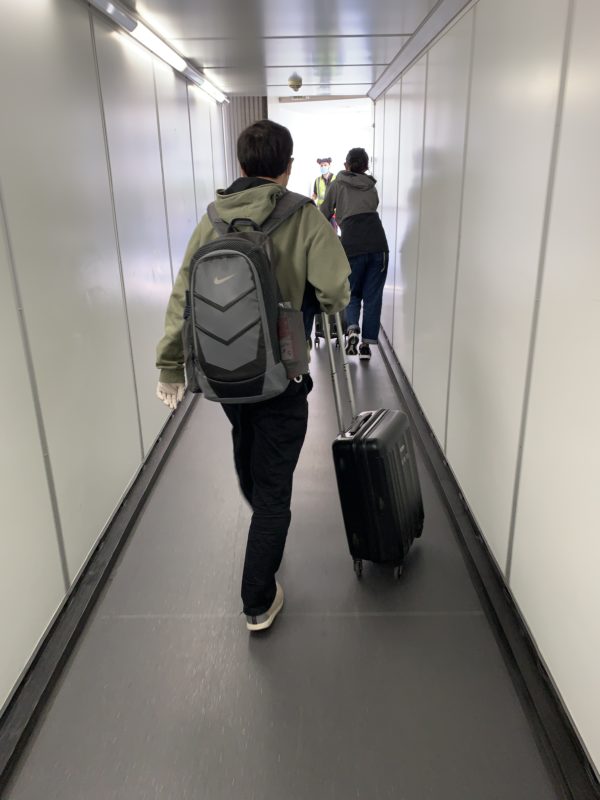 a man with a backpack and luggage on a conveyor belt