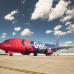a red and blue airplane on a runway