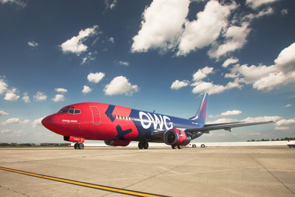 a red and blue airplane on a runway