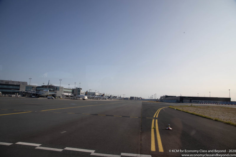 an airport runway with airplanes on the side
