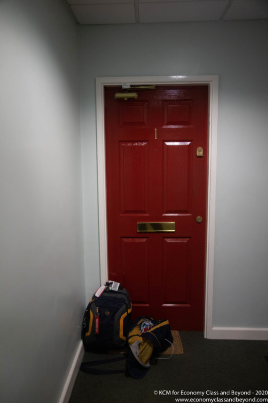 a red door with a backpack in front of it
