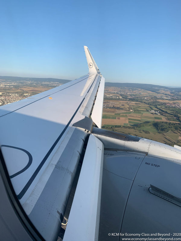 an airplane wing with a landscape in the background