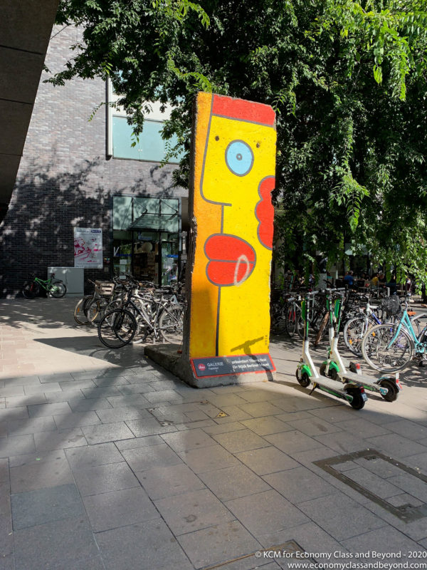 a yellow and red painted wall next to a group of bicycles