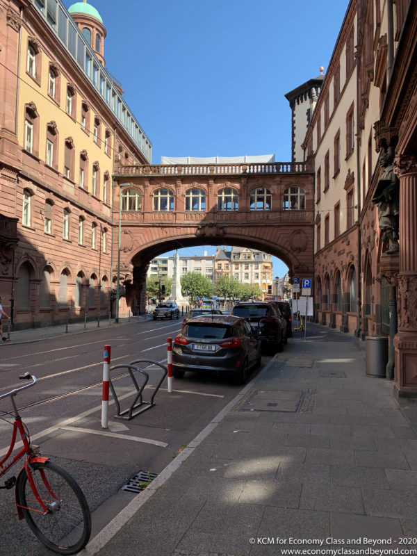 a street with cars parked under a bridge