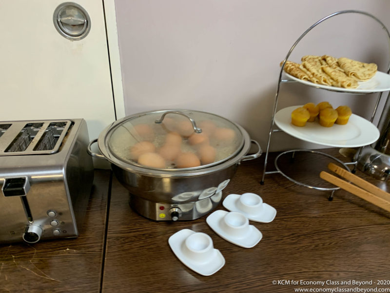 a metal pot with eggs in it next to a toaster and a toaster