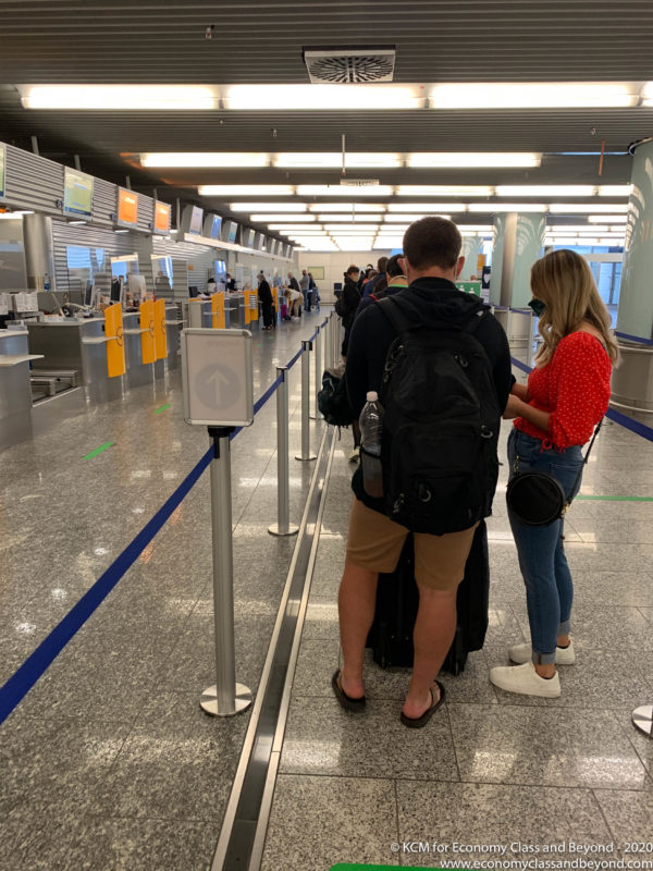 a man and woman standing in a line at an airport