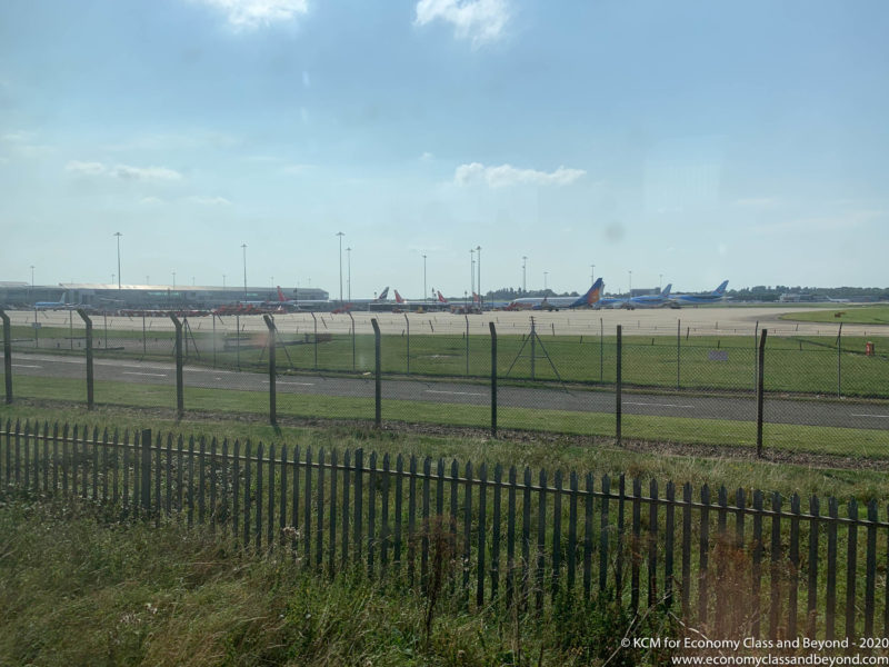 a fenced in area with airplanes on the runway