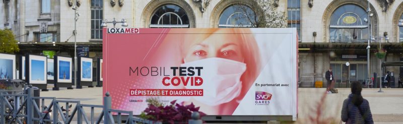 a billboard with a woman wearing a face mask