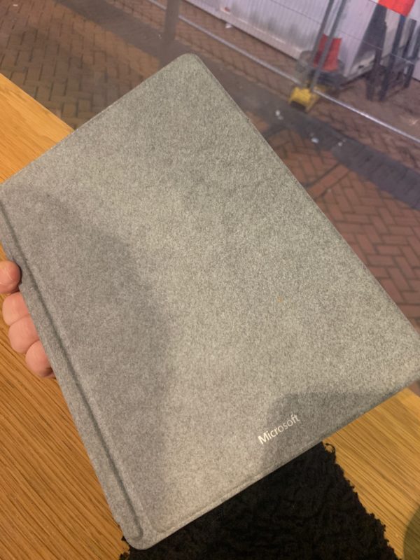 a hand holding a grey book