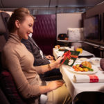 a woman sitting at a table with food and a plate of food