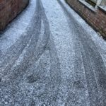 a snow covered road with tire tracks