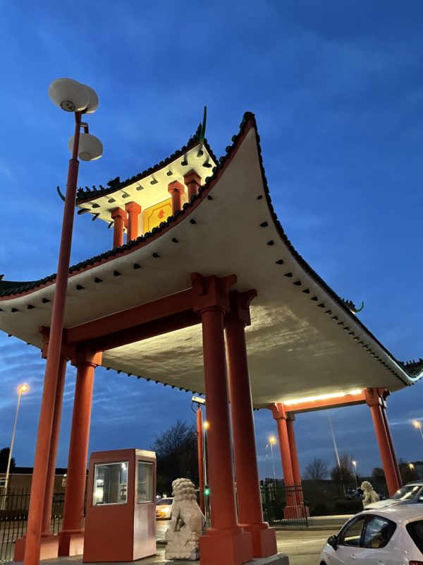 a pagoda with red pillars and a light post