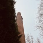 a tall tower with a clock tower and trees