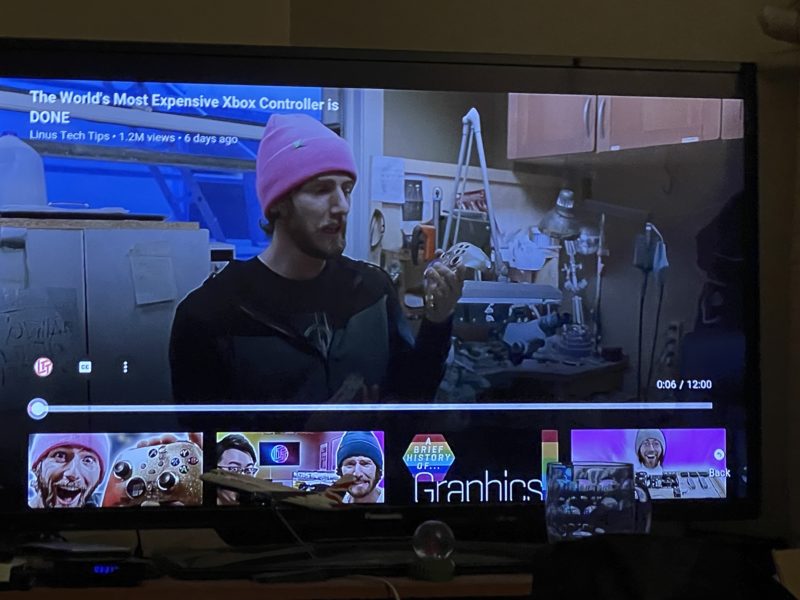 a television screen showing a man wearing a pink hat