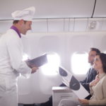 a man in a chef uniform and a woman in a plane