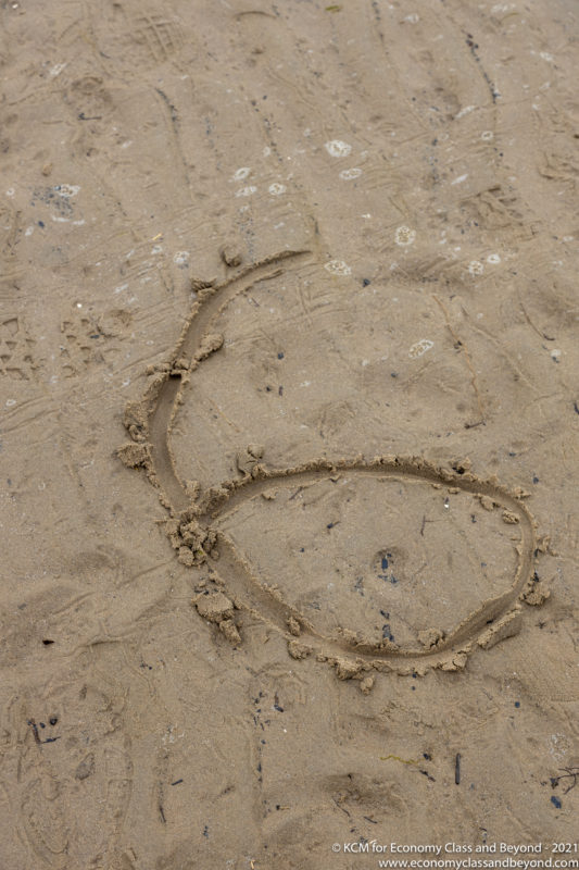 a number six drawn in sand