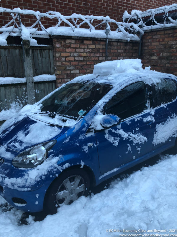 a blue car covered in snow