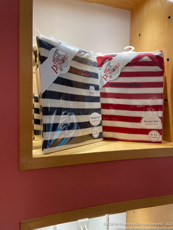 a pair of striped shirts in plastic on a shelf