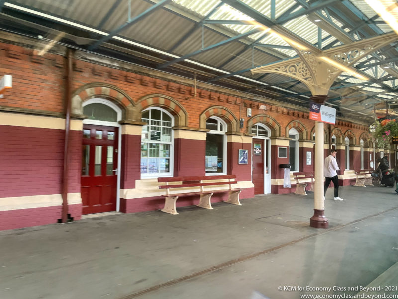 a train station with benches and a man walking