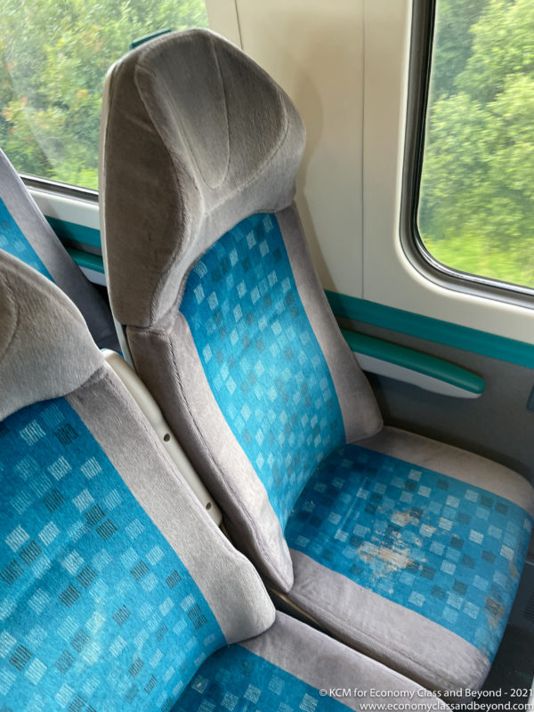 a blue and grey seats in a train