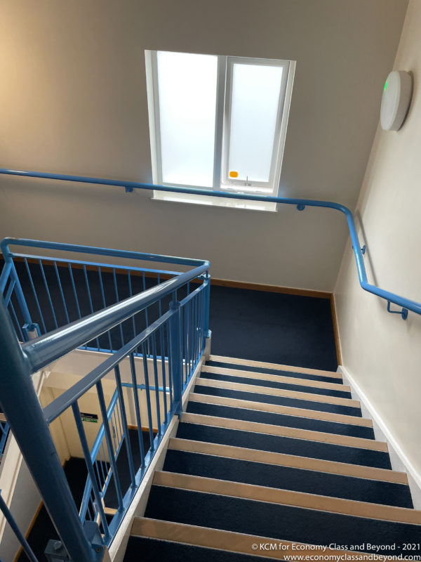 a staircase with blue railings and a window