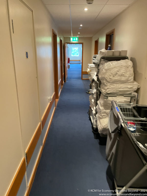a hallway with a cart of towels and a trolley of towels