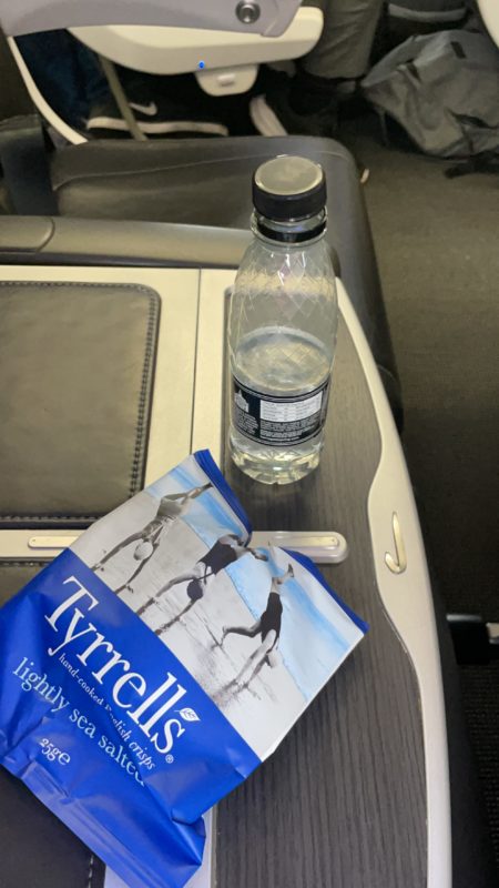 a bottle of water and a bag of food on a table