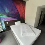 a bed with a colorful wall