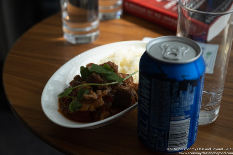 a plate of food and a can of soda on a table
