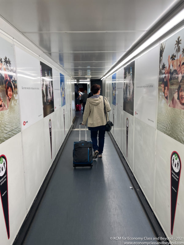 a person walking down a hallway with luggage