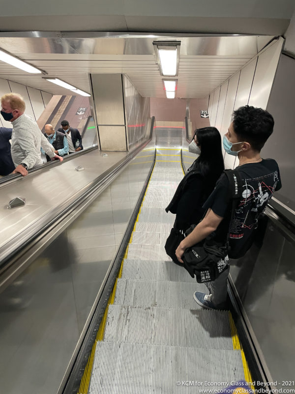 people on an escalator with a mask on