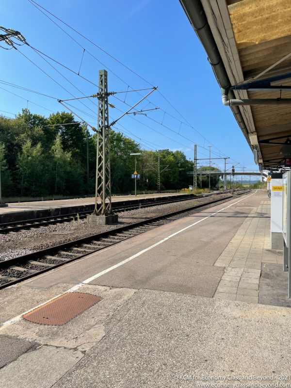 a train station with a train track and power lines
