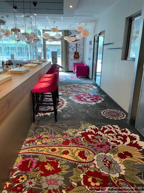 a room with a colorful carpet and a bar with stools