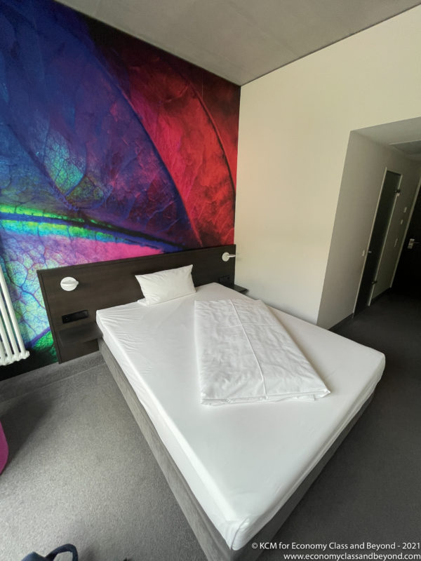 a bed with a colorful wall behind it