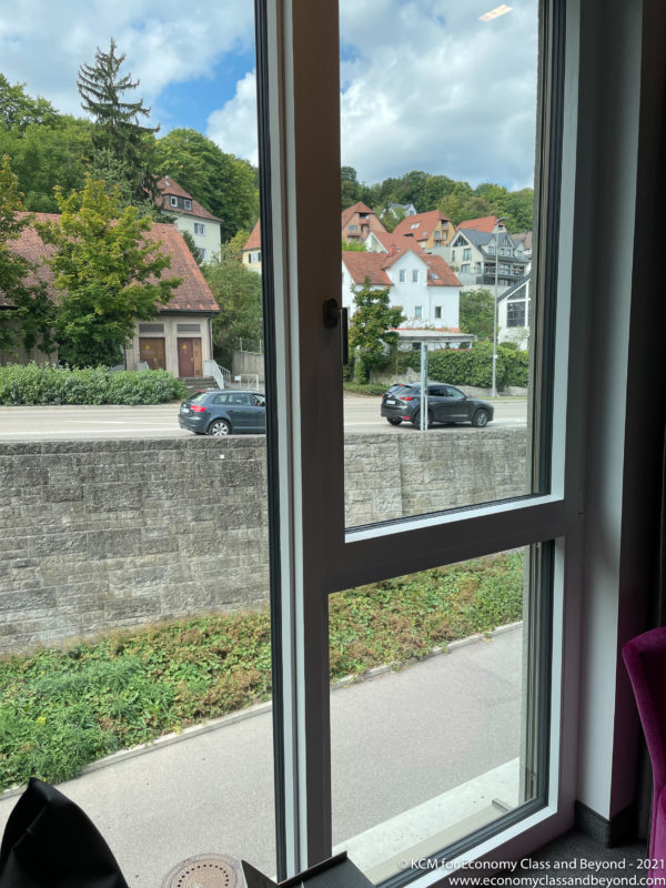 a window with a view of a road and houses