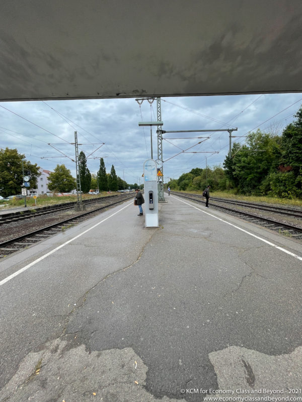 a train tracks and a couple of people walking on a platform