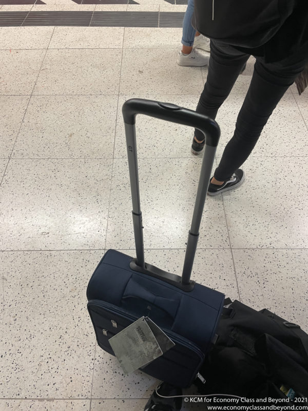 a person's legs and a suitcase