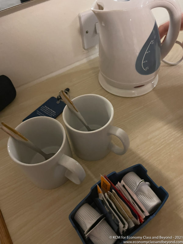 a couple of white mugs with spoons in them