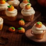 a group of cupcakes with frosting and pumpkins