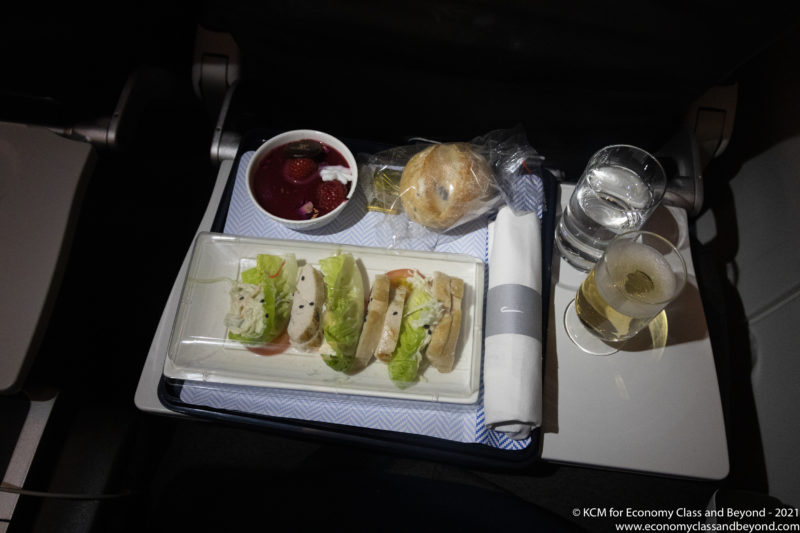 food on a tray with drinks and glasses