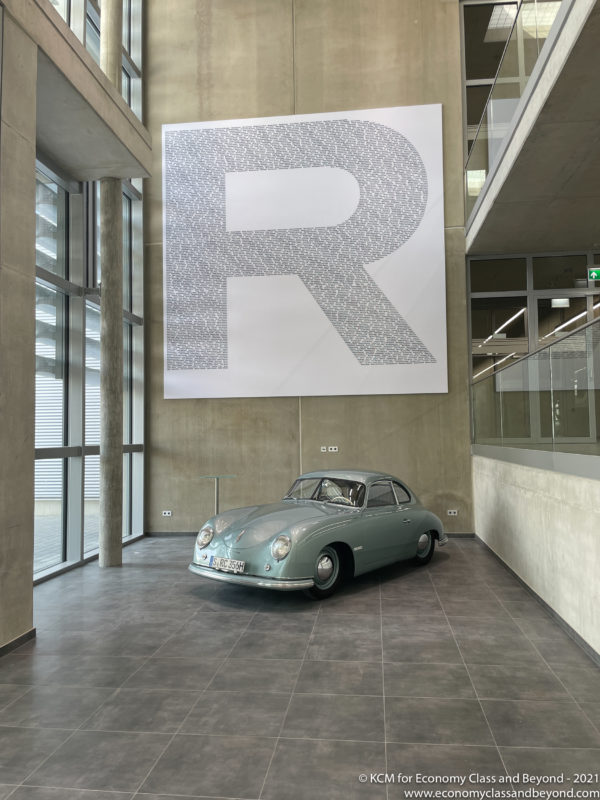 a car in a room with a large sign on the wall