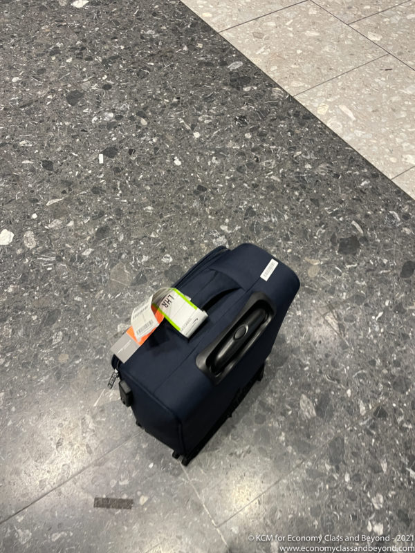 a blue suitcase on a marble floor
