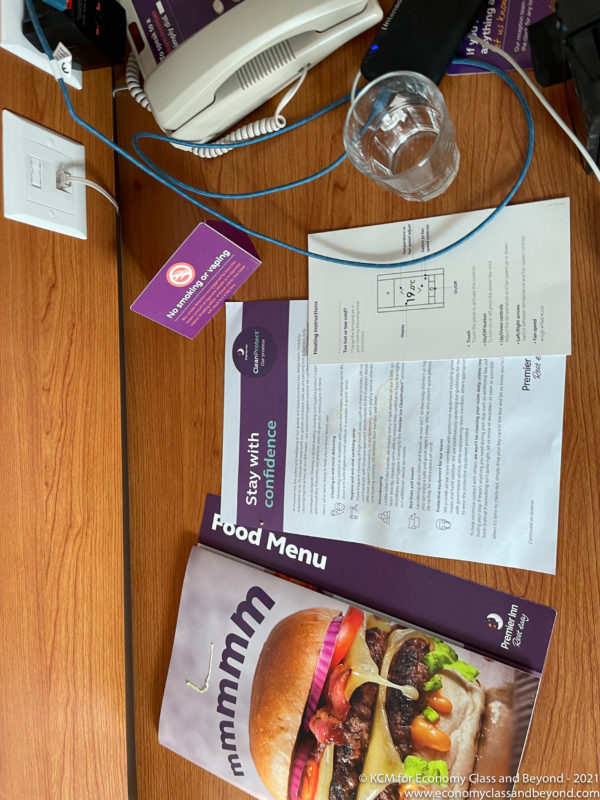 a table with a phone and a glass and a menu on it