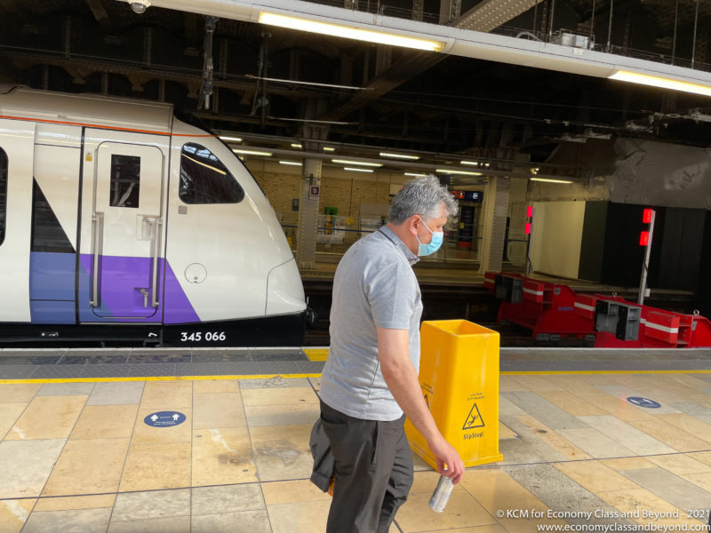 a man wearing a mask and walking in a train station