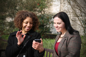 two women looking at a cellphone