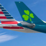 the tail of an airplane with a clover on the tail