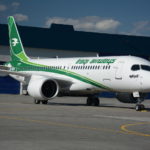 a white and green airplane on a tarmac